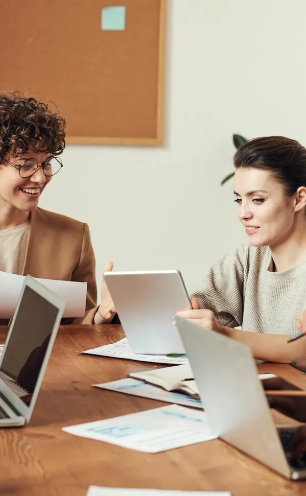 Two women in a meeting with computers